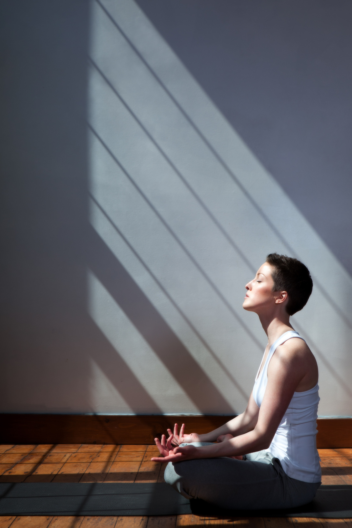 woman meditating in a sun filled room